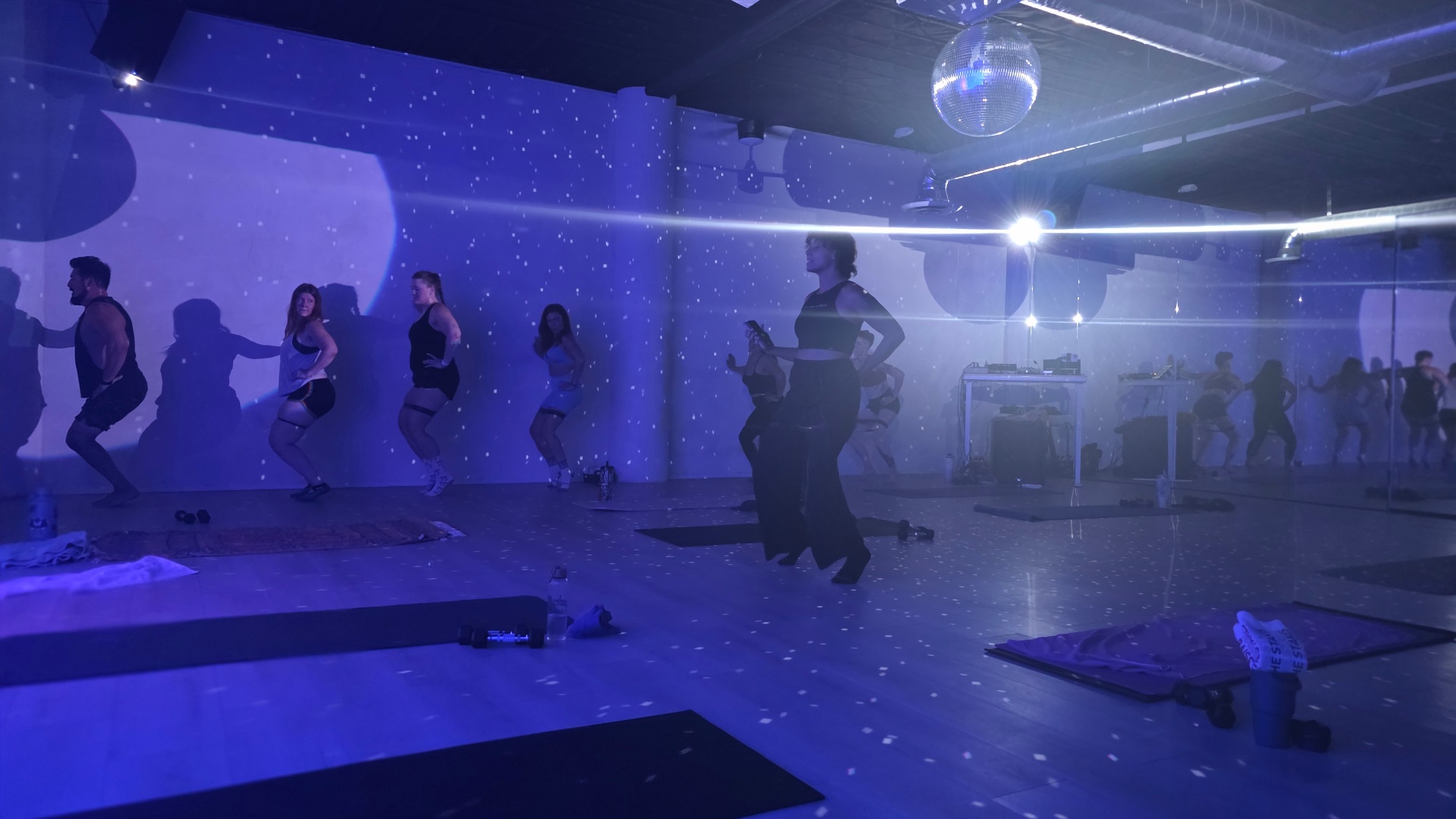 Class flowing under a disco ball in blue haze
